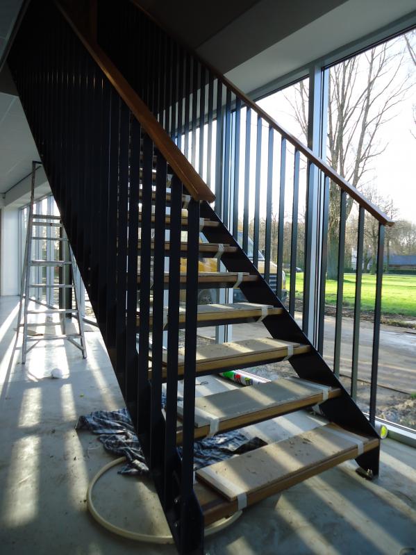 Stalen gepoedercoate trap met houten treden en leuning in een modern kerkgebouw in Dronten.